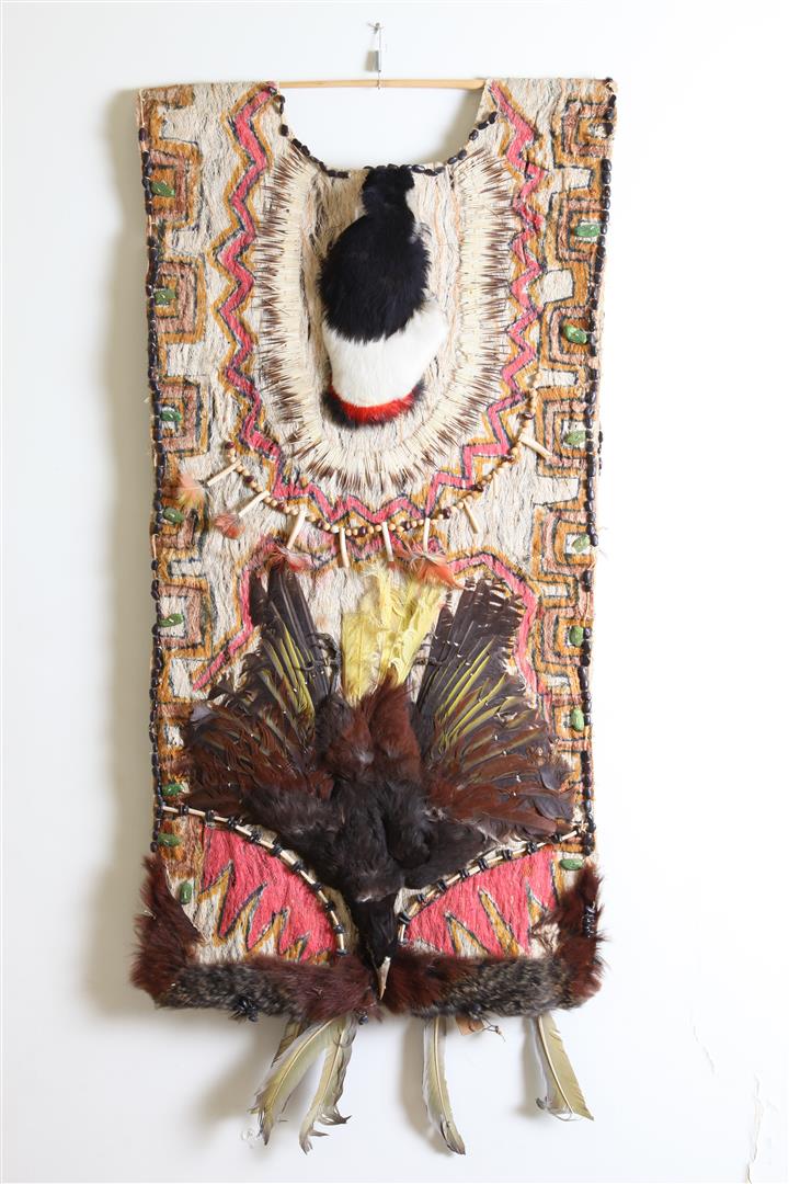 لباس رئیس قبیله جیوارو که از پوست درخت  بافته شده واز پر پرنگان و دانه هایی مانند لوبیا   تزئین شده است.